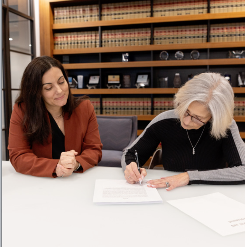A client with her lawyer at her will signing ceremony./ Photo by Bernard DeLierre [cite: 422]